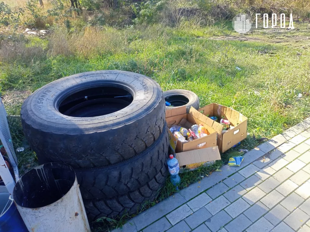 Покрышки и мусор у железнодорожного вокзала Анапы на остановке автобуса.  